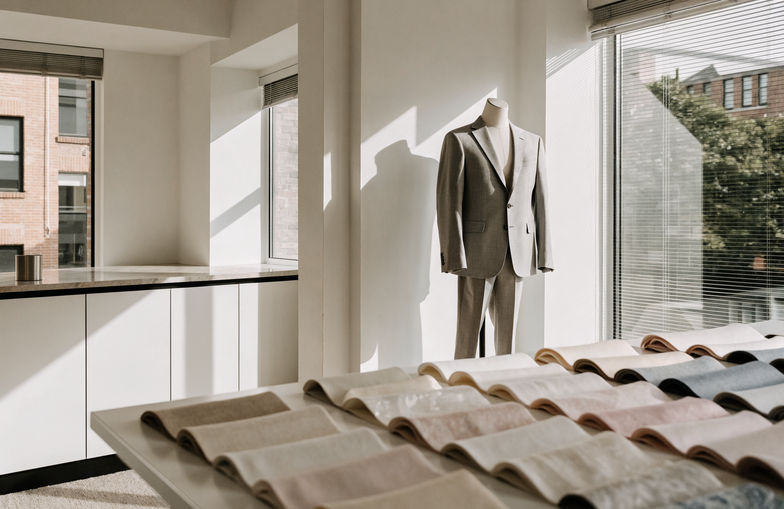 Illustrative image of a modern minimalist tailoring studio with a wedding suit on a mannequin torso