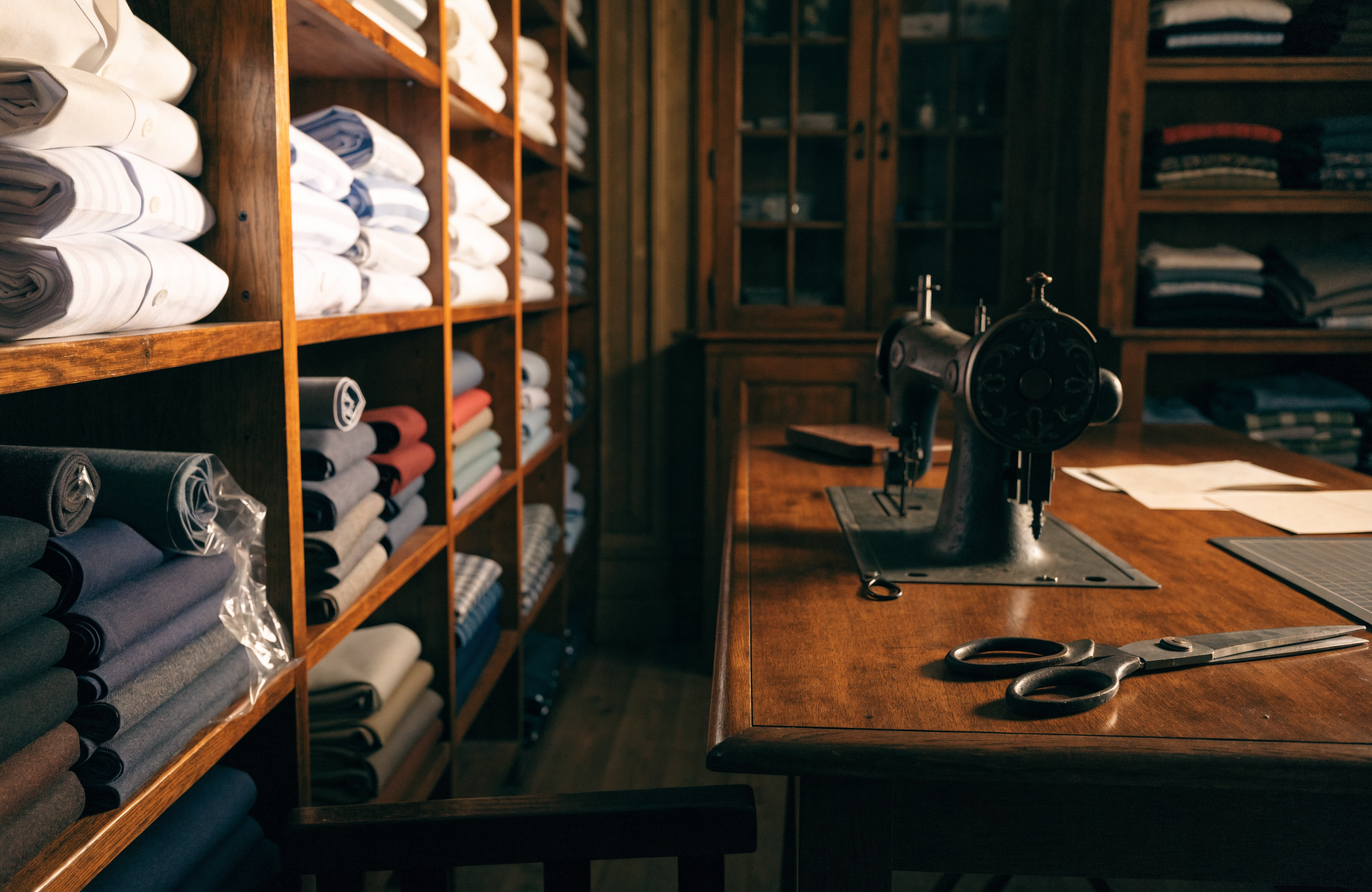 Illustrative image of a heritage tailor shop with fabric bolts and an antique sewing machine