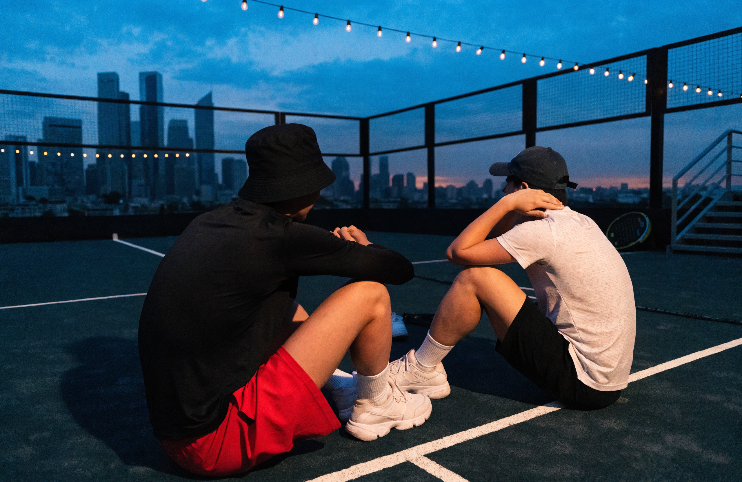 Illustrative rooftop padel court with city skyline at dusk, representing The Padel Co in Singapore