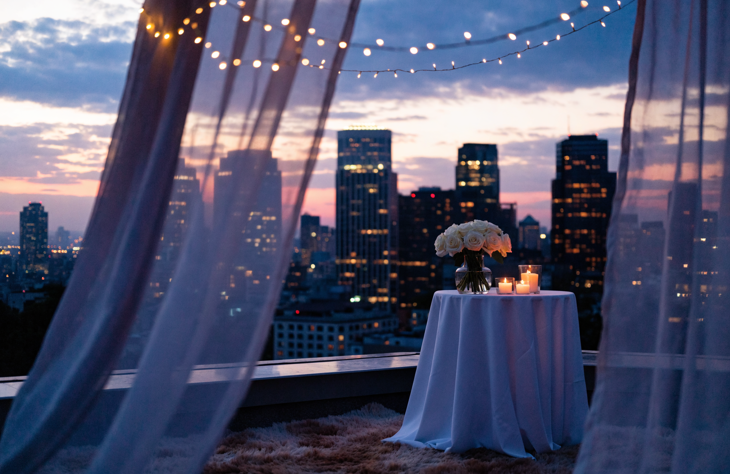 Illustrative rooftop proposal setup overlooking a city skyline at dusk